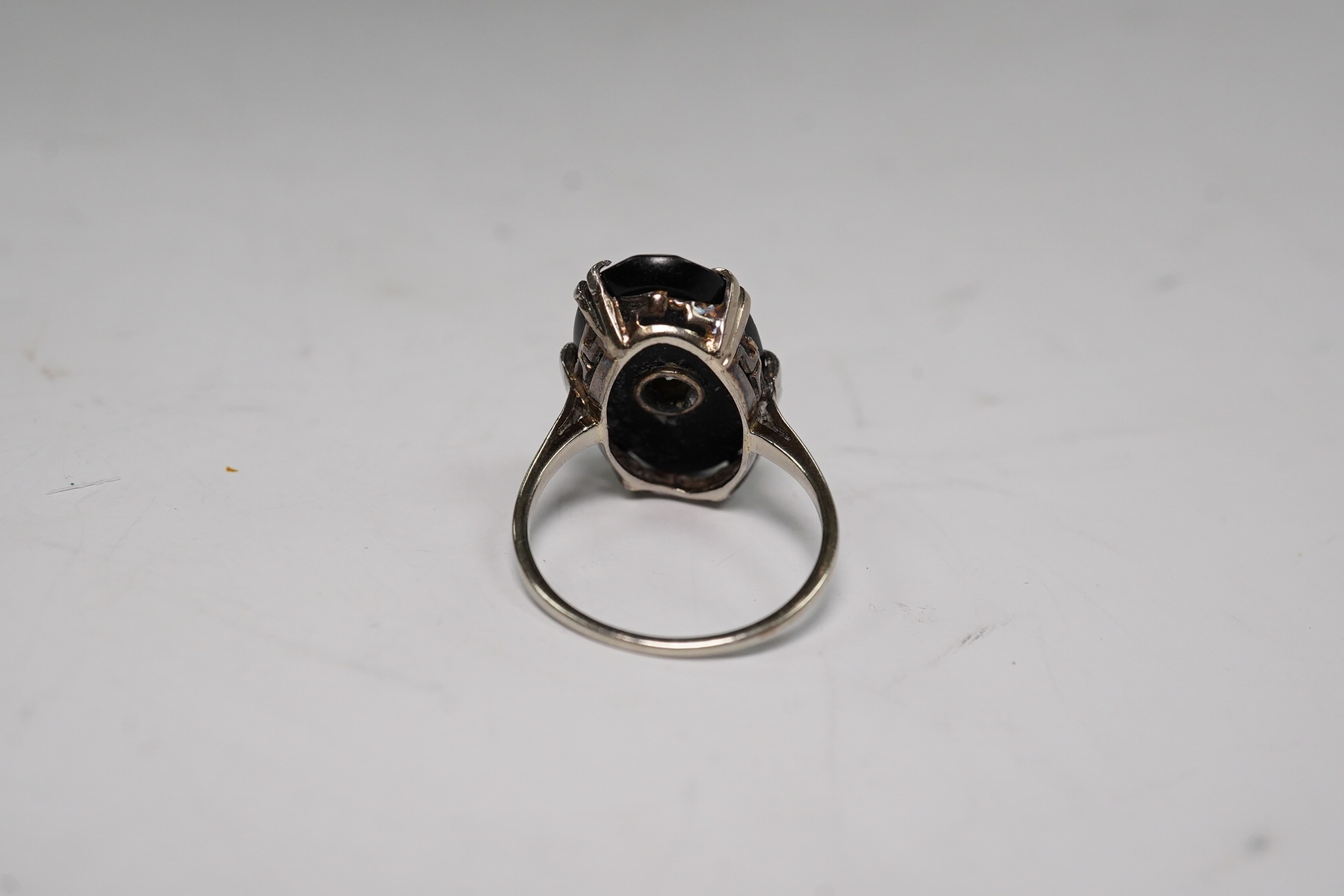 A white metal, black onyx and single stone diamond set oval ring, size M/N, gross weight 3.9 grams. Condition - poor to fair